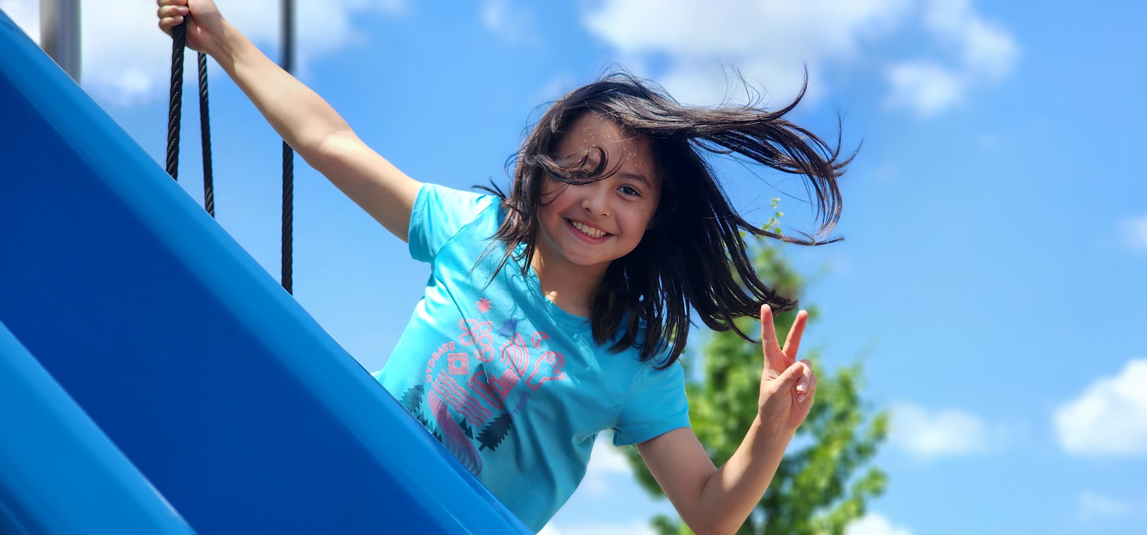 Camper posing on a playground slide
