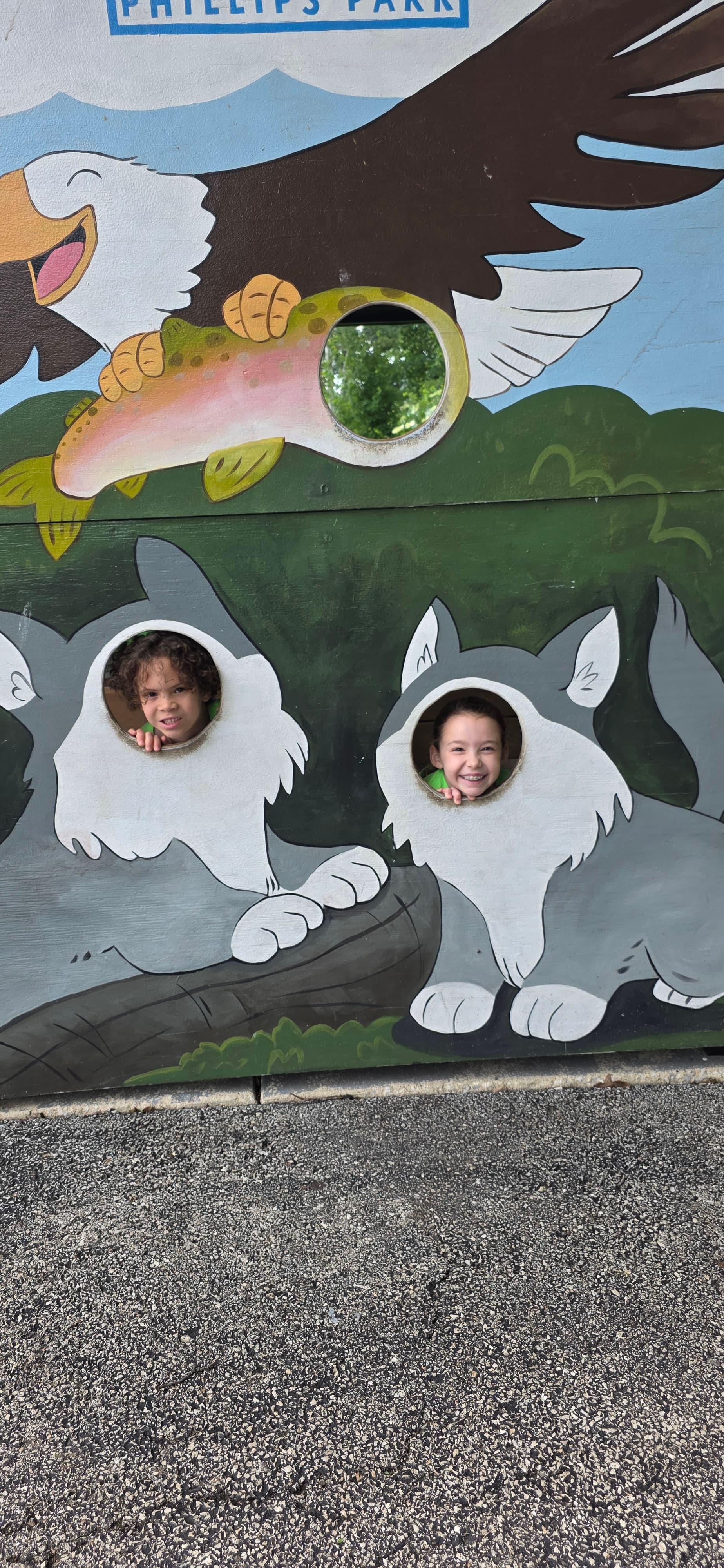 Campers with their faces in a painted cutout board