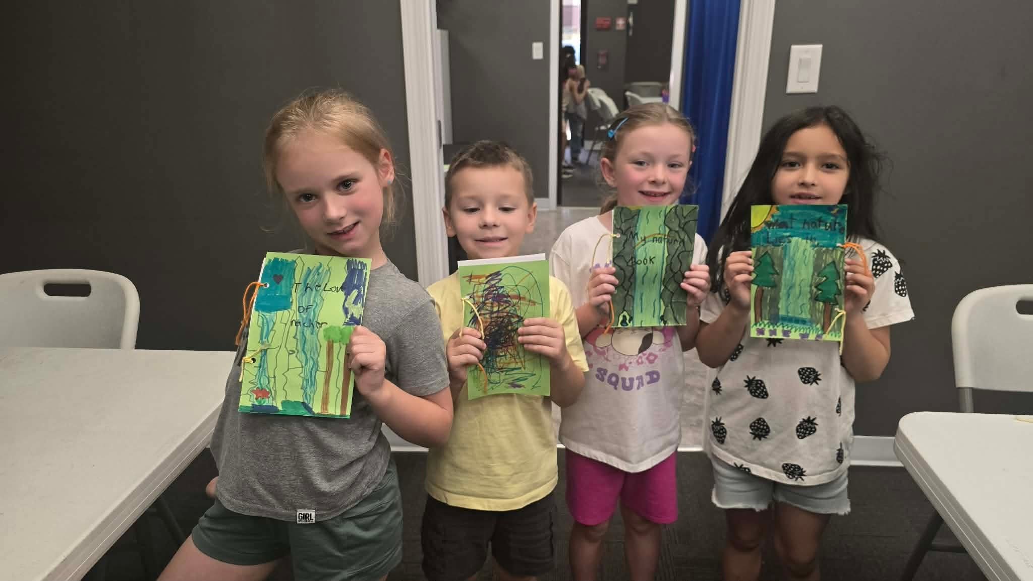 Campers proudly showing their nature books